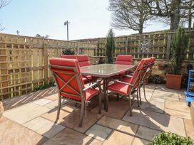 An outdoor seating area with a table and chairs at Cragg Lodge in West Woodburn
