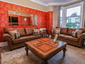 A living room with sofas and a table at Southbourne Manor in Llandudno