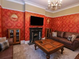 A living room with a television and sofa at Southbourne Manor in Llandudno