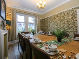 A dining room with a large table set with dishes at Southbourne Manor in Llandudno