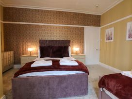 A bedroom with a bed and decorative wall at Southbourne Manor in Llandudno