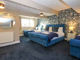 A bedroom with three beds and a mirror at Southbourne Manor in Llandudno