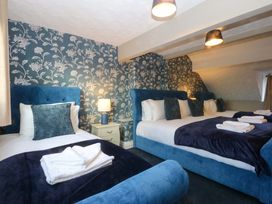 A bedroom with beds and blue decor at Southbourne Manor in Llandudno
