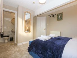 A bedroom with a bed and a bathroom area at Southbourne Manor in Llandudno