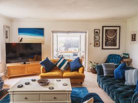 A living room with a sofa and television at Glanllyn Bach in Llanfaelog