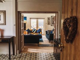 A view into a living room with a sofa and table at Glanllyn Bach, Llanfaelog