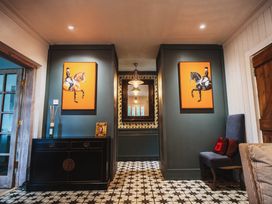 A hallway with paintings and a console table at Glanllyn Bach in Llanfaelog