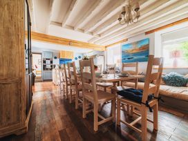 A dining room with a large table and chairs at Glanllyn Bach in Llanfaelog