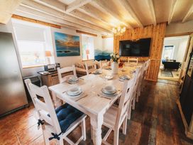 A dining room with a large table and chairs at Glanllyn Bach in Llanfaelog