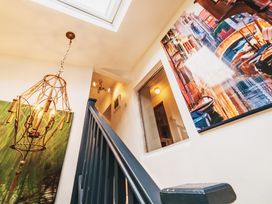 A staircase and chandelier in a hallway at Glanllyn Bach in Llanfaelog