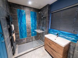A bathroom with a shower and sink at Glanllyn Bach in Llanfaelog