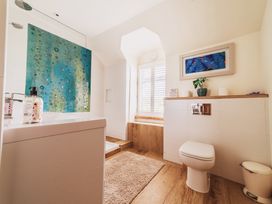 A bathroom with a bathtub, toilet, and sink at Glanllyn Bach Llanfaelog