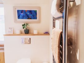 A bathroom with a towel rack and a toilet at Glanllyn Bach Llanfaelog