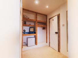 A storage room with shelves and appliances at Glanllyn Bach in Llanfaelog