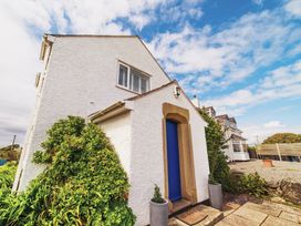 A house with a blue door and plants at Glanllyn Bach in Llanfaelog