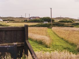 A pathway leading through grass to a building at Glanllyn Bach in Llanfaelog