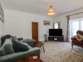 A living room with a sofa and coffee table at Tan Y Merddyn in Ceunant near Llanrug