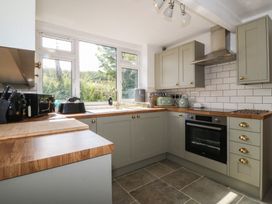 A kitchen with cabinets, oven, and sink at Tan Y Merddyn near Ceunant near Llanrug