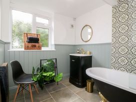 A bathroom with a bathtub and vanity at Tan Y Merddyn in Ceunant near Llanrug