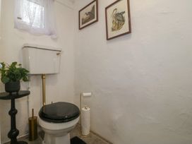 A bathroom with a toilet and side table at Tan Y Merddyn in Ceunant near Llanrug