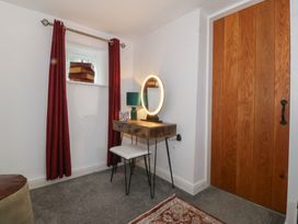 A bedroom with a vanity desk and a mirror at Tan Y Merddyn in Ceunant near Llanrug