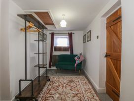 An entryway with a sofa and coat rack at Tan Y Merddyn in Ceunant near Llanrug