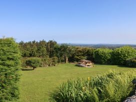 A garden with a picnic table and trees at Tan Y Merddyn Ceunant near Llanrug