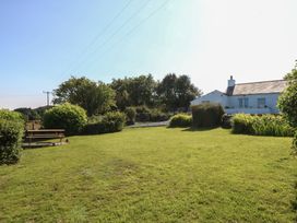 A garden with a bench and house at Tan Y Merddyn Ceunant near Llanrug
