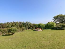 A garden with a picnic table and shrubs at Tan Y Merddyn Ceunant near Llanrug