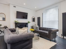 A living room with two gray sofas a wall mounted TV and a glass coffee table at 8 Richmond Road in Exeter