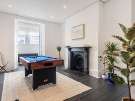 A room with a pool table on a rug and a black fireplace with plants near it at 8 Richmond Road in Exeter