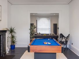 A game room with a pool table and a black and white chair at 8 Richmond Road in Exeter