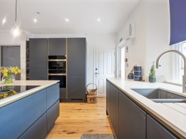 A kitchen with dark cabinets a white countertop a sink and an oven at 8 Richmond Road in Exeter
