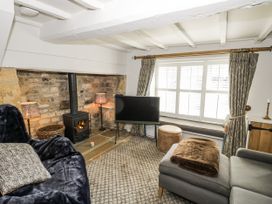 A living room with a sofa and fireplace at Cotstone Cottage in Chipping Campden