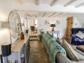 A living room with a sofa and dining area at Cotstone Cottage in Chipping Campden