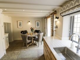A kitchen with a dining table and chairs at Cotstone Cottage in Chipping Campden