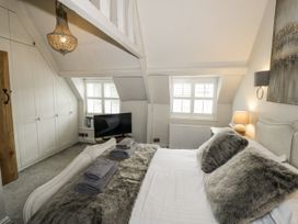 A bedroom with a bed and wardrobe at Cotstone Cottage, Chipping Campden