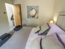 A bedroom with a bed and towels at Cotstone Cottage in Chipping Campden