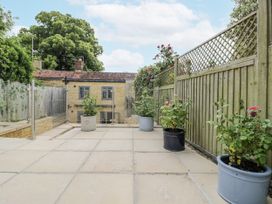 A garden with potted plants and a stone patio at Cotstone Cottage in Chipping Campden