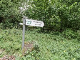 A sign for Snowshill Manor surrounded by foliage at Cotstone Cottage in Chipping Campden