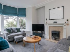 A living room with a sofa and television at The Thistles in Bowness-On-Windermere