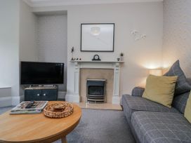 A living room with a television and a coffee table at The Thistles Bowness-On-Windermere