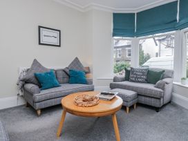 A living room with a sofa and coffee table at The Thistles in Bowness-On-Windermere