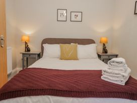 A bedroom with a bed and nightstands at The Thistles in Bowness-On-Windermere