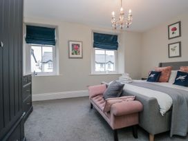 A bedroom with a bed and wardrobe at The Thistles in Bowness-On-Windermere