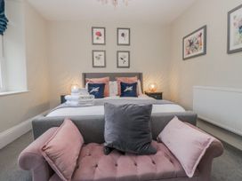 A bedroom with a bed and cushions at The Thistles Bowness-On-Windermere