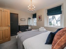 A bedroom with a bed and wardrobe at The Thistles in Bowness-On-Windermere