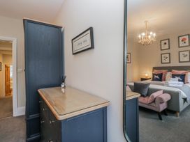 A bedroom with a dresser and mirror at The Thistles in Bowness-On-Windermere