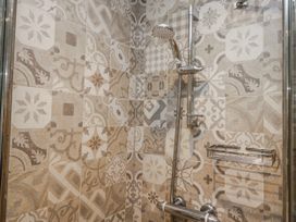 A shower area with patterned tiles at The Thistles Bowness-On-Windermere