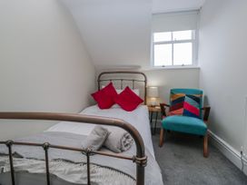 A bedroom with a single bed and chair at The Thistles Bowness-On-Windermere